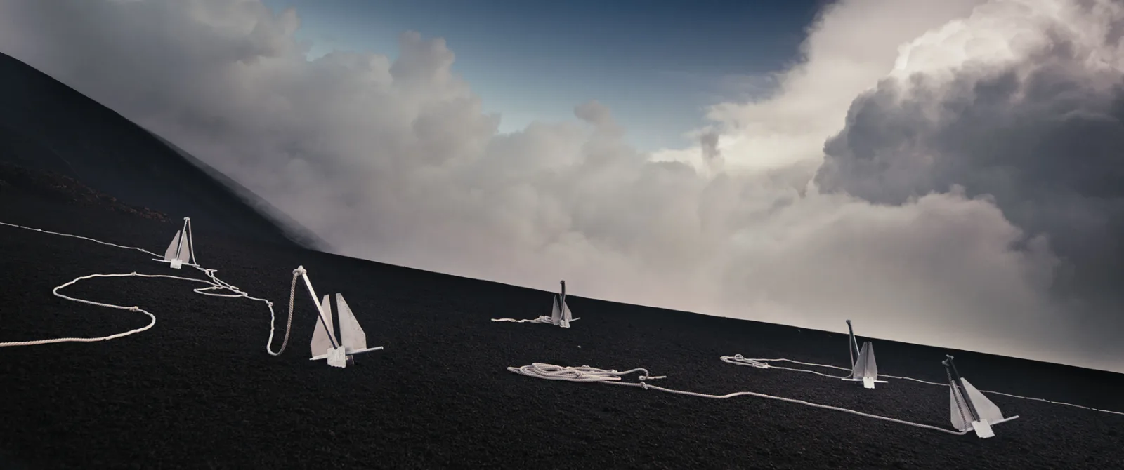 Boat anchors and white rope laid across black volcanic sand on the slopes of Mount Etna, still from She Flickered In and Out of History