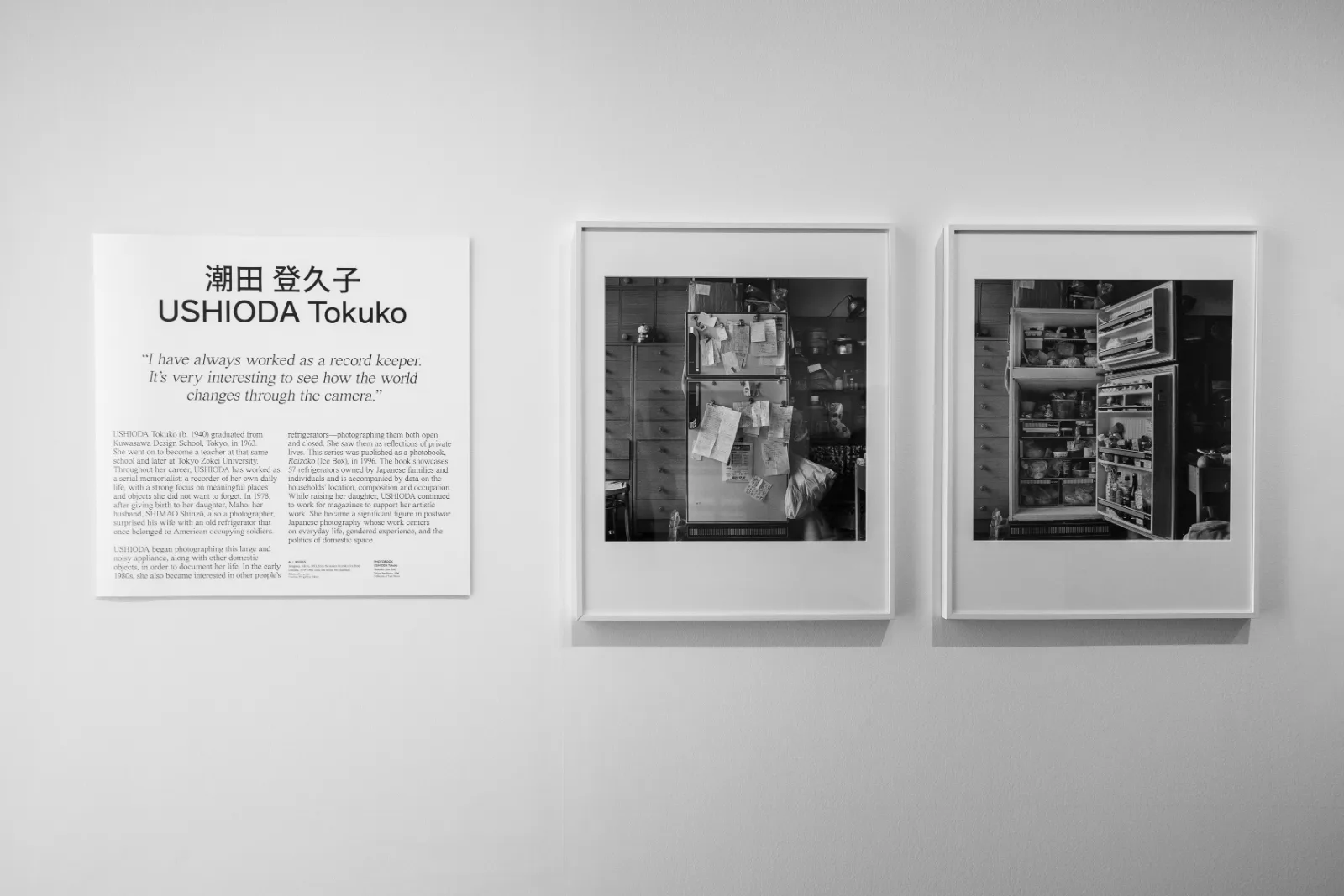 Gallery wall with a wall text for Ushioda Tokuko beside two framed black and white photographs of the same refrigerator in a crowded kitchen, closed and then open