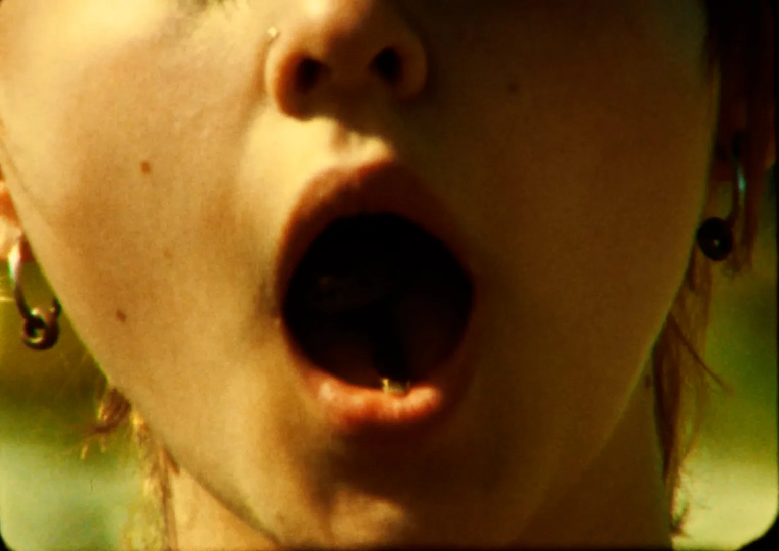 Close-up of Rory Bakker-Marshall with her mouth open, a key visible inside